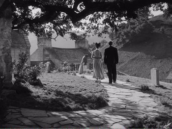 Movie still from “How Green Was My Valley” (1941), directed by John Ford – A man and a woman walking down a stone path; Extreme Wide shot, Low angle