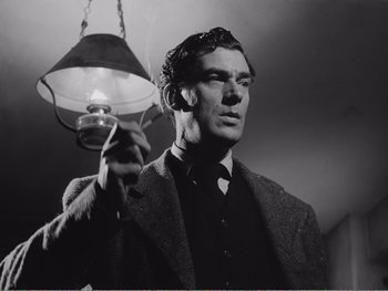 Movie still from “How Green Was My Valley” (1941), directed by John Ford – A black and white photo of a man holding a lamp; Close Up shot, Low angle