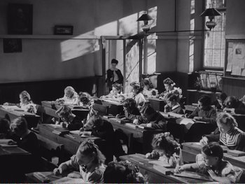 Movie still from “How Green Was My Valley” (1941), directed by John Ford – A group of children sitting at tables in a room; Wide shot, High angle