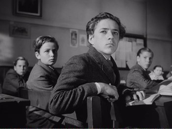 Movie still from “How Green Was My Valley” (1941), directed by John Ford – Black and white photograph of young men in a classroom; Medium shot, Low angle