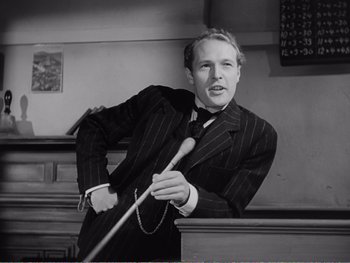 Movie still from “How Green Was My Valley” (1941), directed by John Ford – A black and white photo of a man holding a pool cue; Medium shot, Low angle