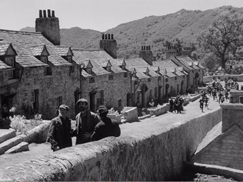 Movie still from “How Green Was My Valley” (1941), directed by John Ford – A black - and - white photo of people standing on the side of a road; Extreme Wide shot, Low angle