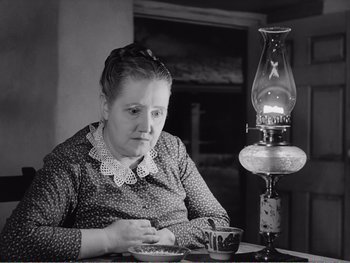 Movie still from “How Green Was My Valley” (1941), directed by John Ford – An older woman sitting in front of an oil lamp; Close Up shot, High angle