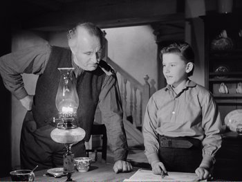Movie still from “How Green Was My Valley” (1941), directed by John Ford – An old photo of a man and a young boy with an oil lamp; Medium shot, Low angle