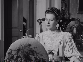 Movie still from “How Green Was My Valley” (1941), directed by John Ford – A black and white photo of a woman sitting in a chair; Medium shot, Over the shoulder angle