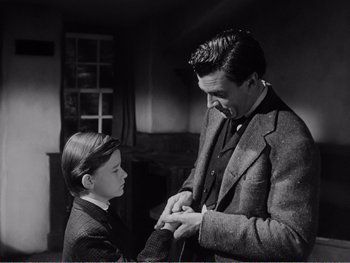 Movie still from “How Green Was My Valley” (1941), directed by John Ford – A man and a young boy in a room with a fireplace in the background; Medium shot, Over the shoulder angle