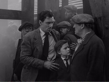 Movie still from “How Green Was My Valley” (1941), directed by John Ford – A group of men standing around each other; Medium shot, High angle