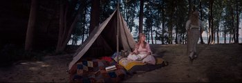 Movie still from “How the West Was Won” (1962), directed by George Marshall – A woman sitting on the ground in front of a teepee; Wide shot, High angle