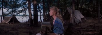 Movie still from “How the West Was Won” (1962), directed by George Marshall – A woman sitting in the woods holding a box; Medium shot, Low angle