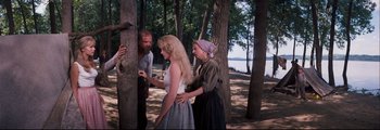Movie still from “How the West Was Won” (1962), directed by George Marshall – Two women and a man standing next to a tree; Medium shot, Over the shoulder angle