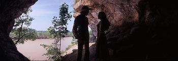 Movie still from “How the West Was Won” (1962), directed by George Marshall – A man and a woman standing next to each other in front of a cliff; Wide shot, Low angle