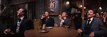 Movie still from “How the West Was Won” (1962), directed by George Marshall – Two men sitting at a dinner table talking on cellphones; Medium shot, Low angle