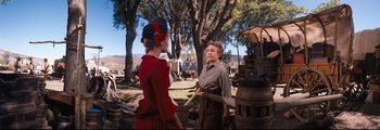 Movie still from “How the West Was Won” (1962), directed by George Marshall – A woman in a red dress is talking to another woman; Medium shot, Over the shoulder angle