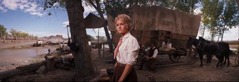 Movie still from “How the West Was Won” (1962), directed by George Marshall – A woman standing in front of a tree in a field; Medium shot, Low angle