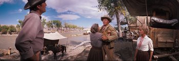 Movie still from “How the West Was Won” (1962), directed by George Marshall – An old woman and a man in a cowboy outfit; Medium shot, Low angle