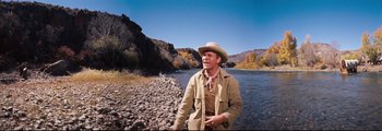 Movie still from “How the West Was Won” (1962), directed by George Marshall – A man in a cowboy hat standing next to a river; Medium shot, Low angle