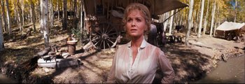 Movie still from “How the West Was Won” (1962), directed by George Marshall – A woman standing in front of an old wagon; Medium shot, Low angle
