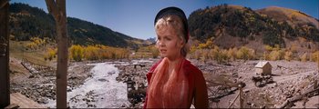 Movie still from “How the West Was Won” (1962), directed by George Marshall – A young blonde woman wearing a hat and a red jacket; Medium shot, Over the shoulder angle