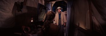 Movie still from “How the West Was Won” (1962), directed by George Marshall – A man and a woman are standing in front of a mirror; Medium shot, Over the shoulder angle