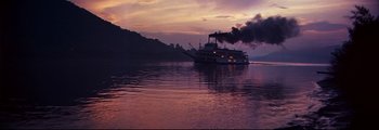 Movie still from “How the West Was Won” (1962), directed by George Marshall – A large boat on a body of water at sunset; Extreme Wide shot, Low angle