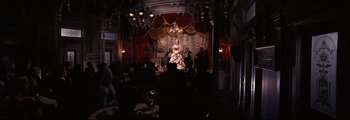 Movie still from “How the West Was Won” (1962), directed by George Marshall – A woman in a white dress sitting in front of a crowd; Wide shot, High angle