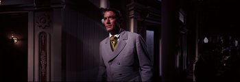 Movie still from “How the West Was Won” (1962), directed by George Marshall – A man wearing a suit and tie standing in a room; Medium shot, Low angle