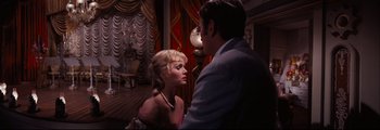 Movie still from “How the West Was Won” (1962), directed by George Marshall – A man and a woman are standing in front of a lamp; Medium shot, Over the shoulder angle