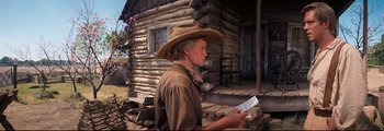 Movie still from “How the West Was Won” (1962), directed by George Marshall – A woman in a cowboy hat holding papers; Medium shot, Low angle
