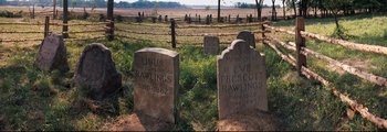 Movie still from “How the West Was Won” (1962), directed by George Marshall – A group of tombstones sitting in the grass; Wide shot, High angle
