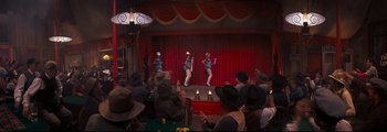 Movie still from “How the West Was Won” (1962), directed by George Marshall – A group of women performing on a stage with red drapes; Wide shot, High angle