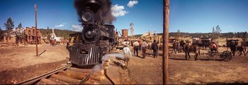 Movie still from “How the West Was Won” (1962), directed by George Marshall – A group of people standing next to an old train; Extreme Wide shot, Low angle