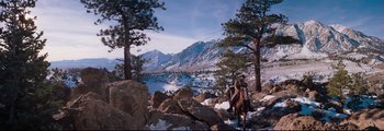 Movie still from “How the West Was Won” (1962), directed by George Marshall – A man riding a horse through the snow covered mountains; Extreme Wide shot, Low angle