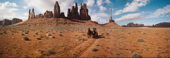Movie still from “How the West Was Won” (1962), directed by George Marshall – A group of horses pulling a carriage down a dirt road; Extreme Wide shot, High angle