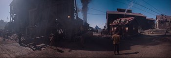Movie still from “How the West Was Won” (1962), directed by George Marshall – People are standing in front of a building with smoke billowing out of it; Extreme Wide shot, High angle