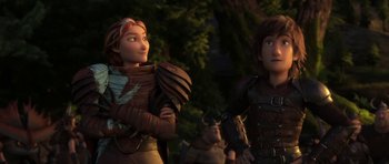 Movie still from “How to Train Your Dragon: The Hidden World” (2019), directed by Dean DeBlois – A couple of people standing next to each other in front of trees; Medium shot, Low angle