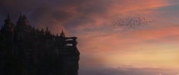 Movie still from “How to Train Your Dragon: The Hidden World” (2019), directed by Dean DeBlois – A flock of birds flying in the sky over a cliff at sunset; Extreme Wide shot, Low angle