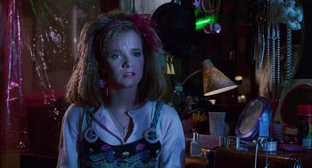 Movie still from “Howard the Duck” (1986), directed by Willard Huyck – A woman with a pink bow in her hair; Close Up shot, Over the shoulder angle