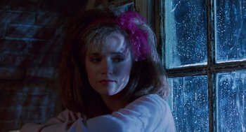 Movie still from “Howard the Duck” (1986), directed by Willard Huyck – A woman with a pink flower in her hair; Close Up shot, Low angle