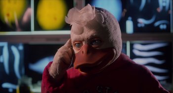 Movie still from “Howard the Duck” (1986), directed by Willard Huyck – A person wearing a duck mask and a red sweater; Close Up shot, Low angle