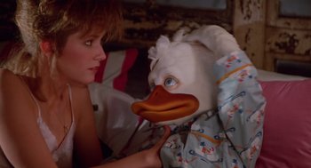Movie still from “Howard the Duck” (1986), directed by Willard Huyck – A person with a duck mask in their hands; Close Up shot, Low angle