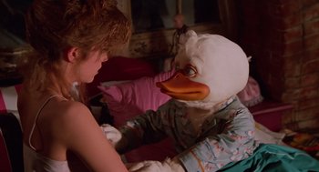 Movie still from “Howard the Duck” (1986), directed by Willard Huyck – A person wearing a duck mask with a woman; Close Up shot, Over the shoulder angle
