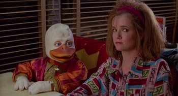 Movie still from “Howard the Duck” (1986), directed by Willard Huyck – A woman sitting next to a stuffed duck doll; Medium shot, Over the shoulder angle