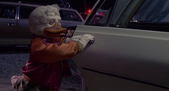 Movie still from “Howard the Duck” (1986), directed by Willard Huyck – An animal that is holding the door handle of a car; Close Up shot, Low angle