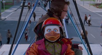Movie still from “Howard the Duck” (1986), directed by Willard Huyck – A person wearing a helmet and a duck mask; Close Up shot, Low angle