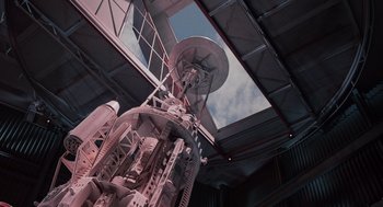 Movie still from “Howard the Duck” (1986), directed by Willard Huyck – Looking up at a very tall tower with a satellite dish on top; Extreme Wide shot, Overhead angle