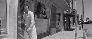 Movie still from “Hud” (1963), directed by Martin Ritt – An old photo of a man walking down the street; Wide shot, Low angle