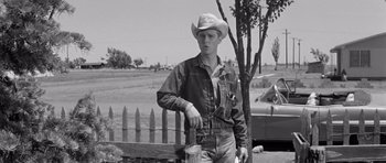 Movie still from “Hud” (1963), directed by Martin Ritt – A man in a cowboy hat standing next to a fence; Medium shot, Low angle
