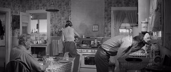 Movie still from “Hud” (1963), directed by Martin Ritt – Two people in a kitchen preparing food on a stove; Wide shot, Low angle
