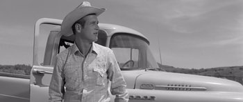 Movie still from “Hud” (1963), directed by Martin Ritt – A man wearing a cowboy hat standing in front of a truck; Medium shot, Low angle