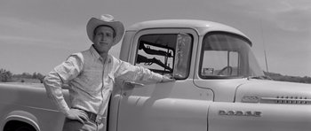 Movie still from “Hud” (1963), directed by Martin Ritt – A man in a cowboy hat standing in front of a truck; Medium shot, Low angle